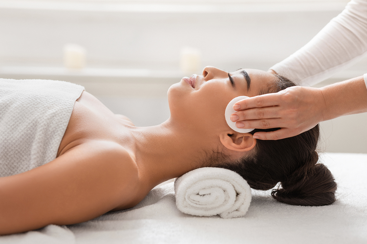 estetista esegue trattamento estetico viso ad una giovane donna